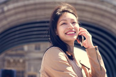 Genç bir kadın cep telefonuyla konuşuyor.