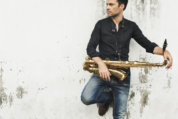 Musicien tenant un saxophone — Photo