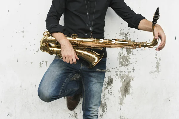 Muzikant holding saxofoon — Stockfoto