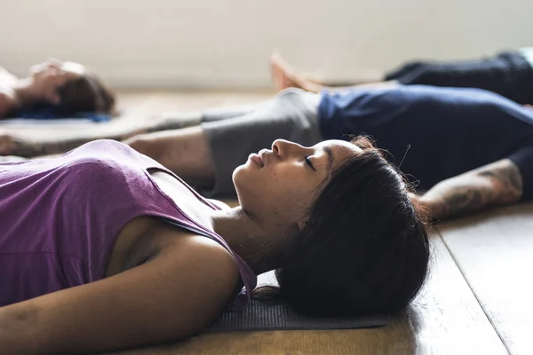 Люди лежать на йога килимі — стокове фото