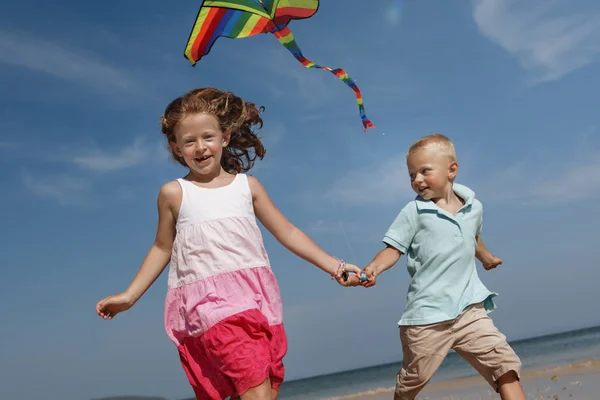 Kinderen spelen Kite op strand — Stockfoto