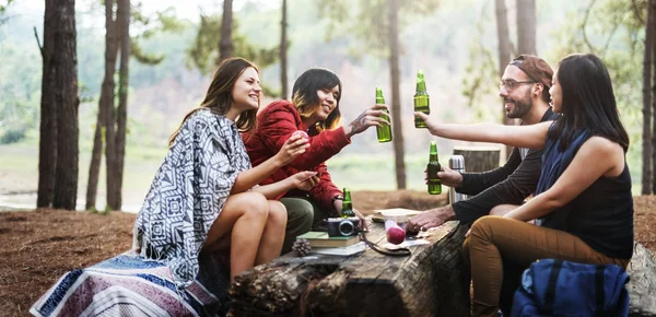 Amigos que têm bebidas no acampamento — Fotografia de Stock