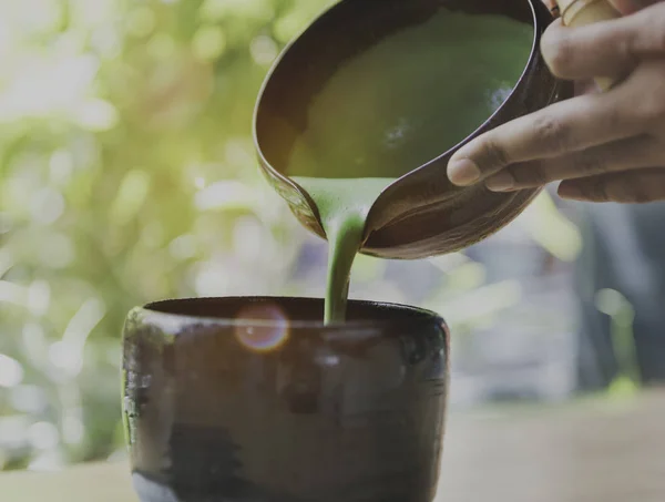 Handen gieten thee in de beker — Stockfoto