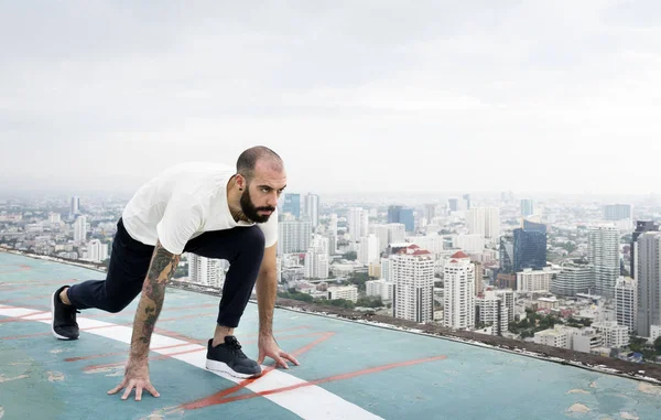 Hombre haciendo ejercicio en la azotea — Foto de Stock