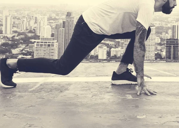 Hombre haciendo ejercicio en la azotea — Foto de Stock