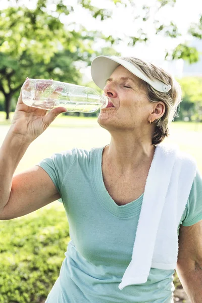Старша жінка п'є воду — стокове фото