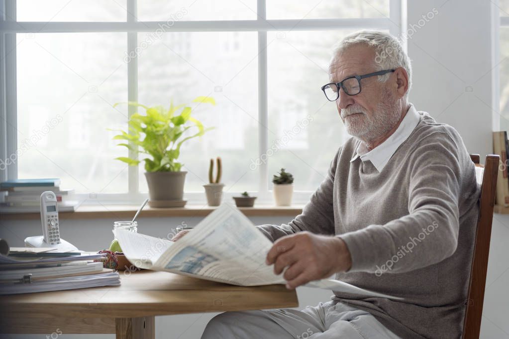 senior man reading newspaper