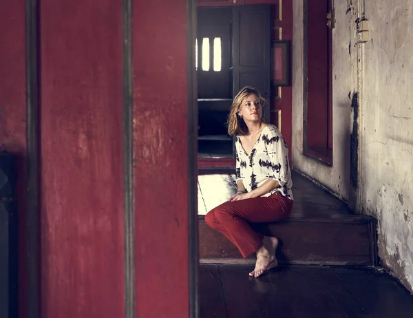 Молода жінка сидить на сходах — стокове фото