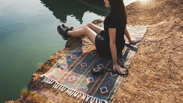 Mujer sentada cerca del lago — Foto de Stock