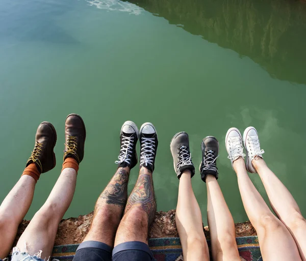 Amici viaggiatori seduti sulla roccia — Foto Stock