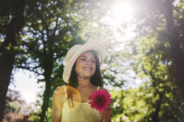 Chica en sombrero sosteniendo flor — Foto de Stock