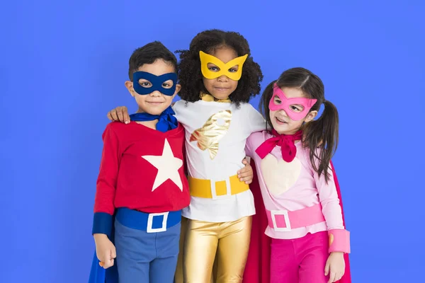 Superhrdina děti objímat a pózování — Stock fotografie