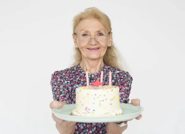 Senior mulher segurando bolo de aniversário — Fotografia de Stock