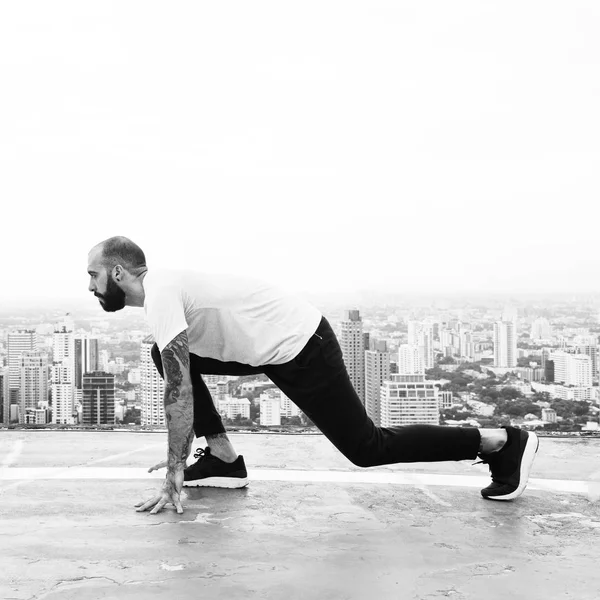 Hombre haciendo ejercicio en la azotea — Foto de Stock