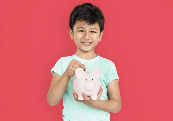 Boy putting money in the piggy bank — Stock Photo, Image