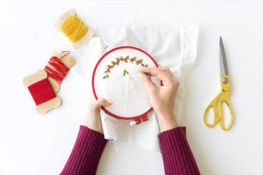 Kız bir kumaş üzerine embroiders