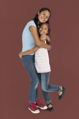 Kız kardeşler birbirlerine sarılıyorlar.