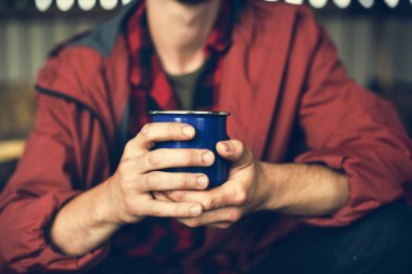 Kupa sıcak içecek ile tutan adam