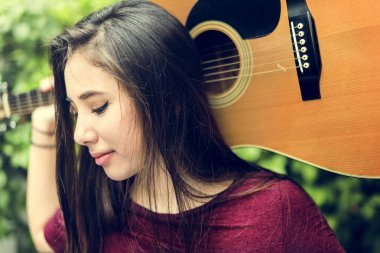 genç bir kadın tutarak gitar