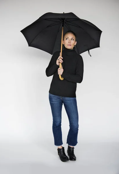 Blonde woman in black with umbrella — Stock Photo, Image