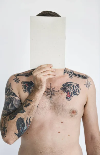 Uomo con tatuaggi in possesso di carta — Foto Stock