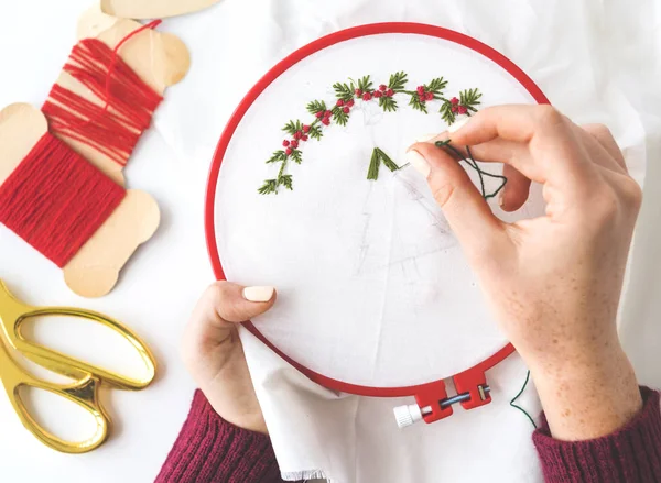 Kız bir kumaş üzerine embroiders