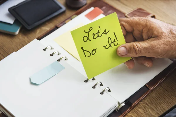 Persona che tiene nota bastone giallo — Foto Stock