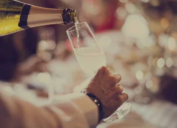 Der Kellner gießt Champagner in ein Glas — Stockfoto