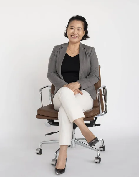 Азиатка сидит на стуле — стоковое фото
