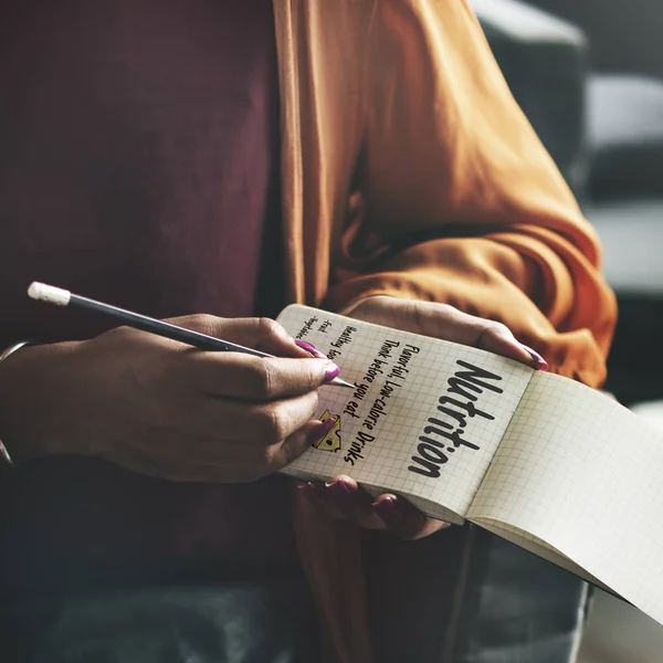 Mulher escrevendo notas em pequeno caderno — Fotografia de Stock