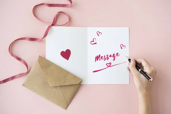 Manos humanas escribiendo en la tarjeta de felicitación — Foto de Stock