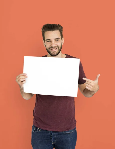 Homem mostrando papel em branco e sorrindo — Fotografia de Stock