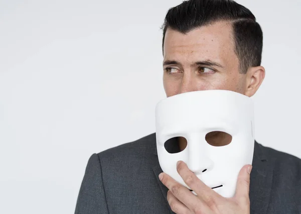 Бизнесмен держит маску — стоковое фото