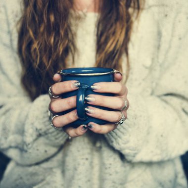 Kupa sıcak içecek ile tutan kadın