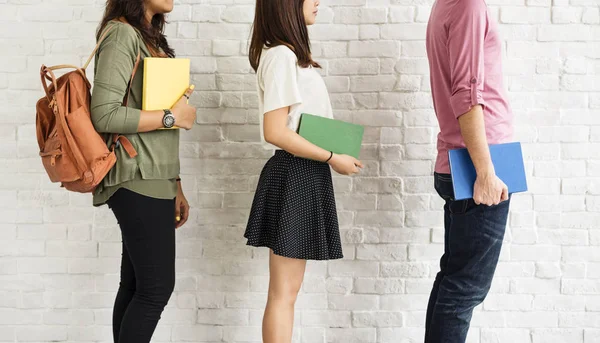 Studenter står mot vit vägg — Stockfoto