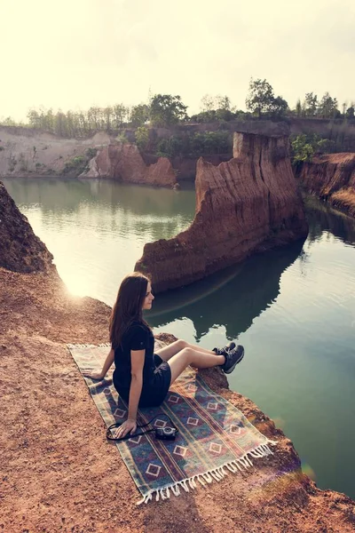 Mujer viajera sentada en el rock — Foto de Stock