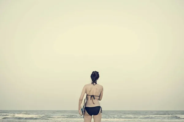 ビーチでサーフィンを持つ女性 — ストック写真