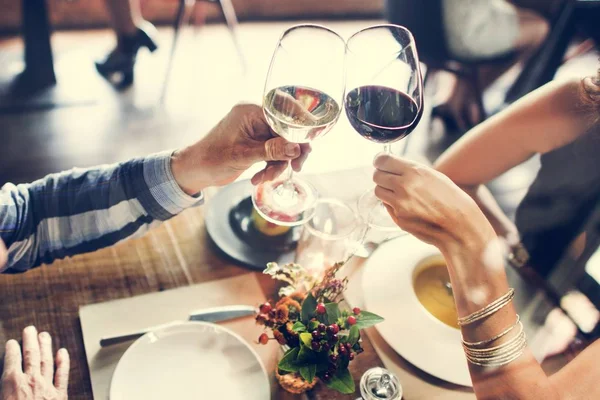 Människor jublar med glas vinstockar — Stockfoto