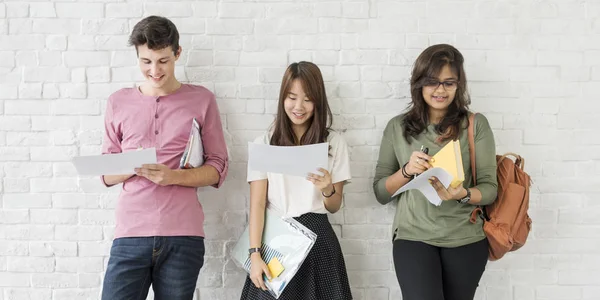 Studenten stehen vor weißer Wand — Stockfoto