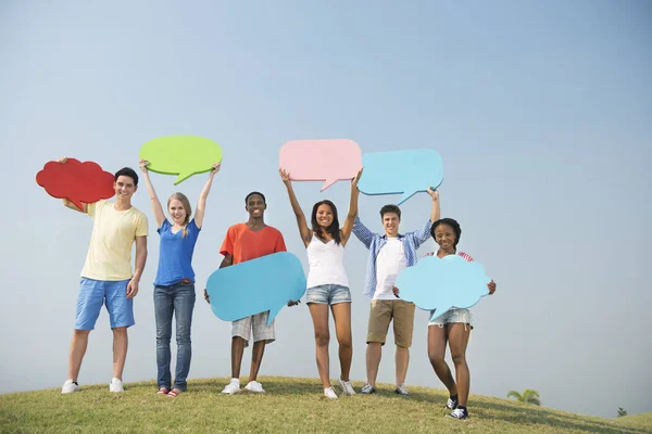 Friends outdoors holding speech bubbles — Stock Photo, Image