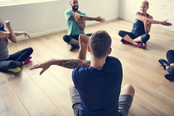 Група людей займається розтягуванням йоги — стокове фото