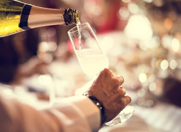 Der Kellner gießt Champagner in ein Glas — Stockfoto