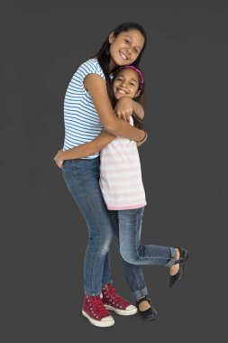 Kız kardeşler birbirlerine sarılıyorlar.