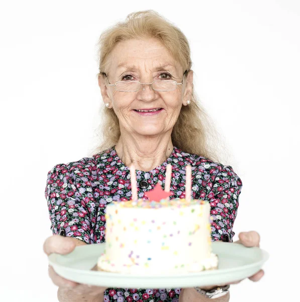 Senior mulher segurando bolo de aniversário — Fotografia de Stock