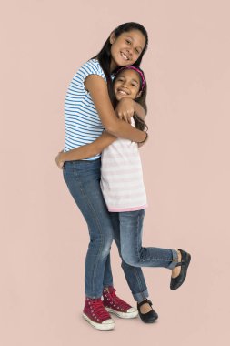 Kız kardeşler birbirlerine sarılıyorlar.