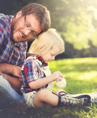 Baba ve oğul çimenlerin üzerinde oturan
