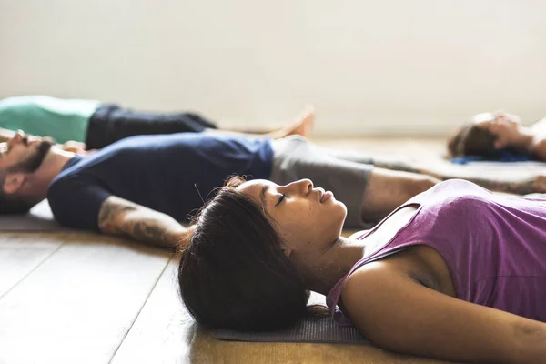 Люди, лежащие на ковре для йоги — стоковое фото