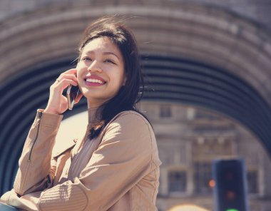 Genç bir kadın cep telefonuyla konuşuyor.