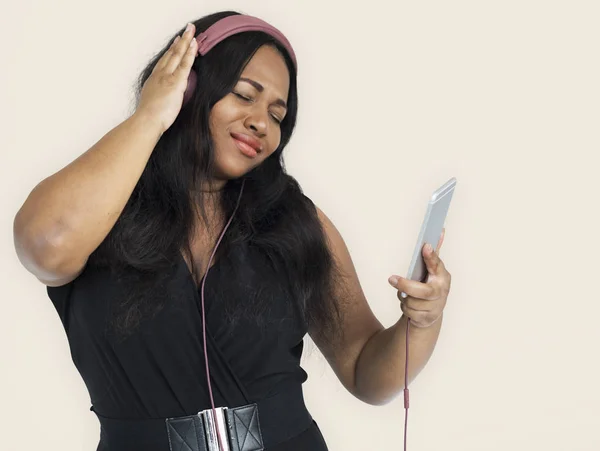 Afrikaanse vrouw luisteren muziek in hoofdtelefoons — Stockfoto