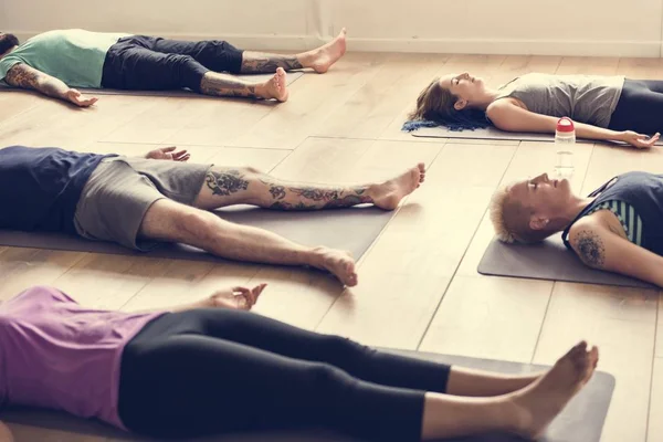 Gente acostada en alfombra de yoga — Foto de Stock